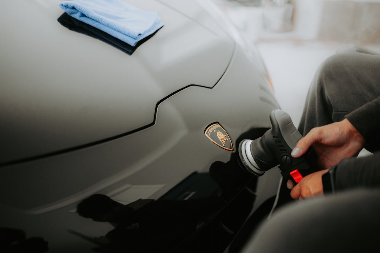 Detailed shot of a Lamborghini being polished, showcasing an automotive care process in a garage.